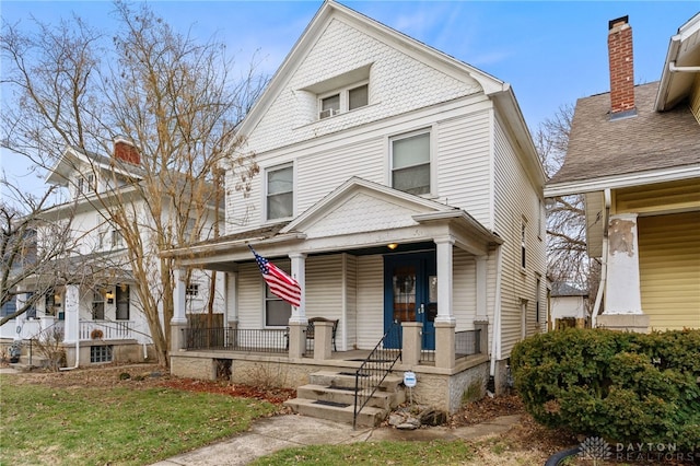 american foursquare style home featuring a porch