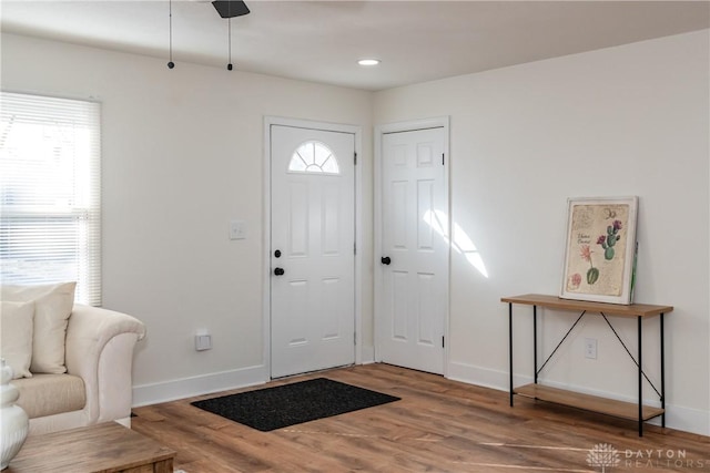 foyer entrance with baseboards, wood finished floors, and recessed lighting