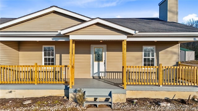 exterior space featuring a porch and roof with shingles