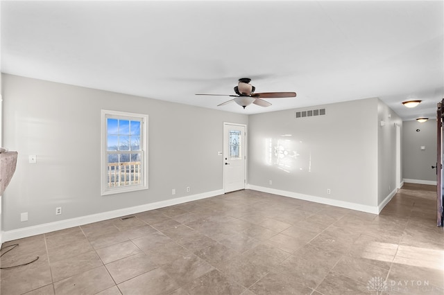 empty room with visible vents, ceiling fan, and baseboards