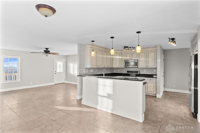 kitchen with baseboards, a ceiling fan, dark countertops, stainless steel appliances, and cream cabinetry