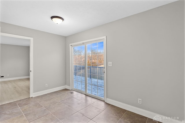 unfurnished room featuring tile patterned flooring and baseboards