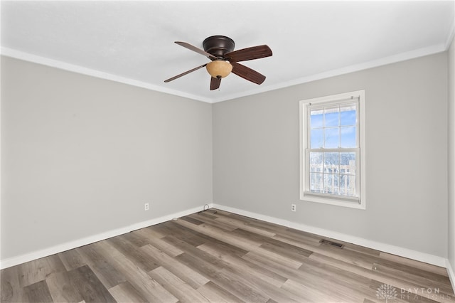 unfurnished room featuring ornamental molding, visible vents, baseboards, and wood finished floors