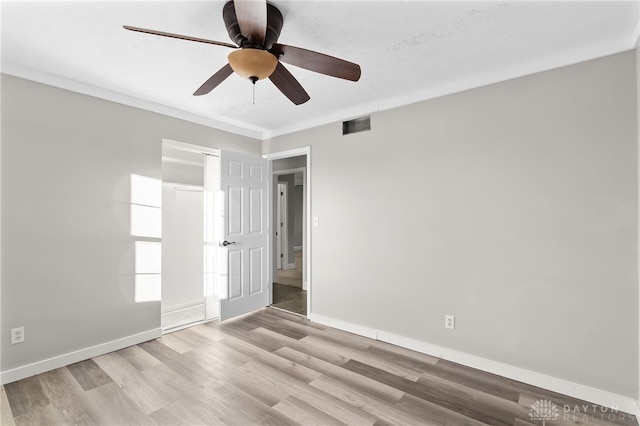 spare room featuring a ceiling fan, baseboards, visible vents, and light wood finished floors