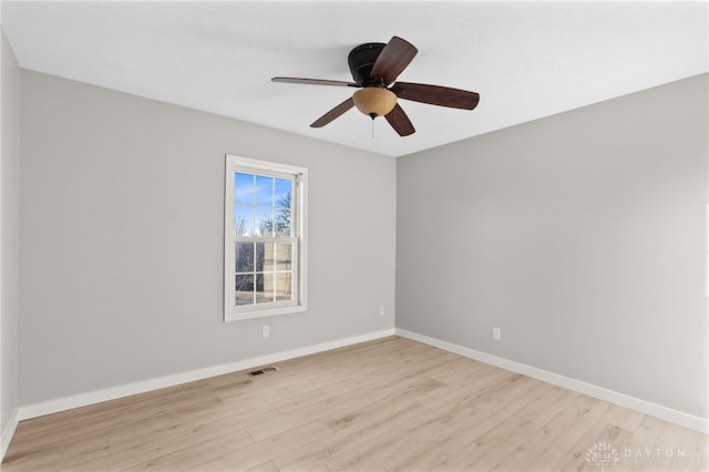 unfurnished room featuring light wood-style flooring, visible vents, baseboards, and ceiling fan