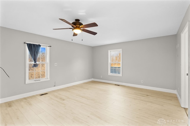 unfurnished room featuring light wood-type flooring, baseboards, visible vents, and a ceiling fan