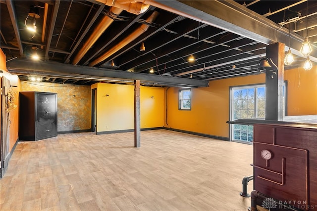 basement featuring wood finished floors and baseboards