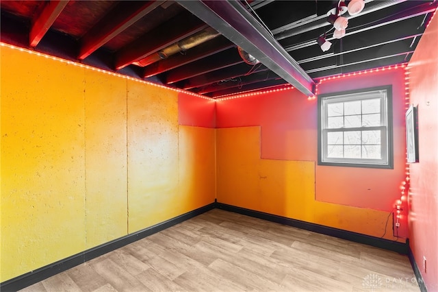 basement with baseboards and light wood finished floors