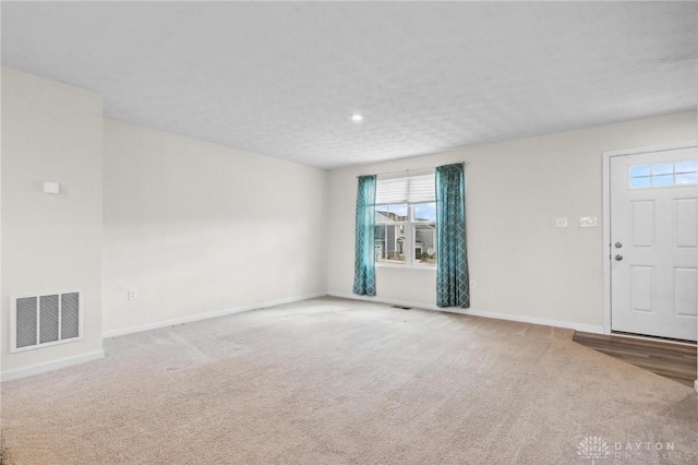 interior space featuring carpet, baseboards, and visible vents