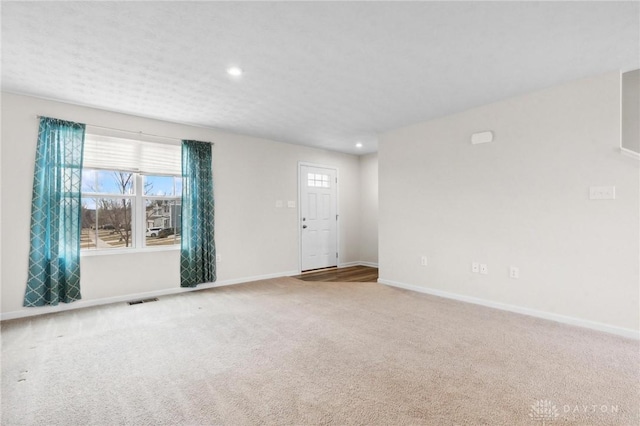 spare room with carpet floors, baseboards, visible vents, and recessed lighting