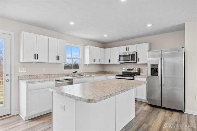 kitchen with appliances with stainless steel finishes, a sink, and white cabinets