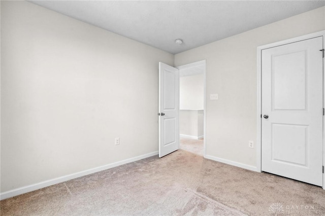 unfurnished bedroom featuring carpet and baseboards