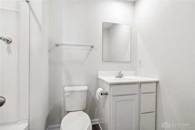 bathroom with toilet, walk in shower, and vanity