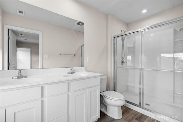 full bathroom featuring a stall shower, a sink, and toilet