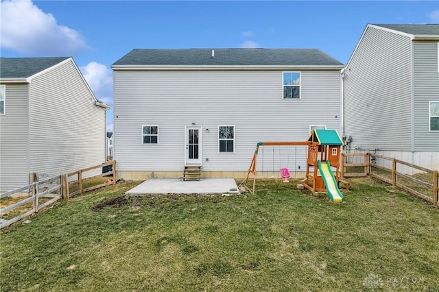 rear view of property featuring a playground, a patio, a lawn, entry steps, and a fenced backyard