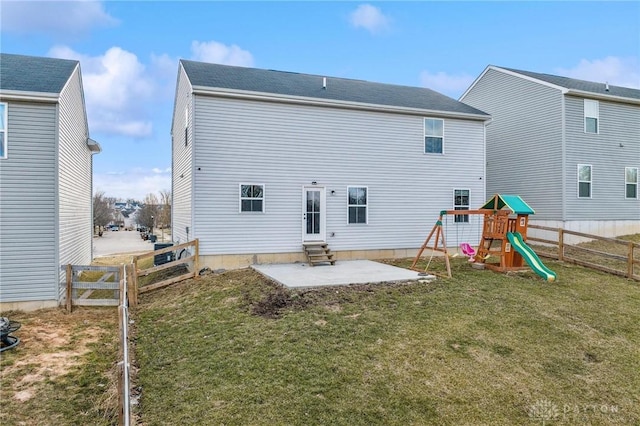 rear view of house featuring entry steps, a patio, a playground, a fenced backyard, and a yard