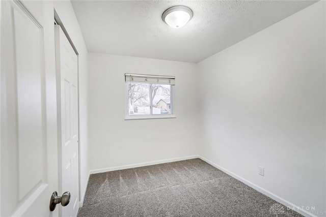 unfurnished bedroom featuring a textured ceiling, carpet floors, a closet, and baseboards