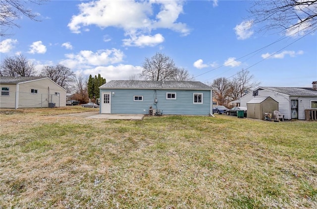 back of property with an outbuilding and a yard