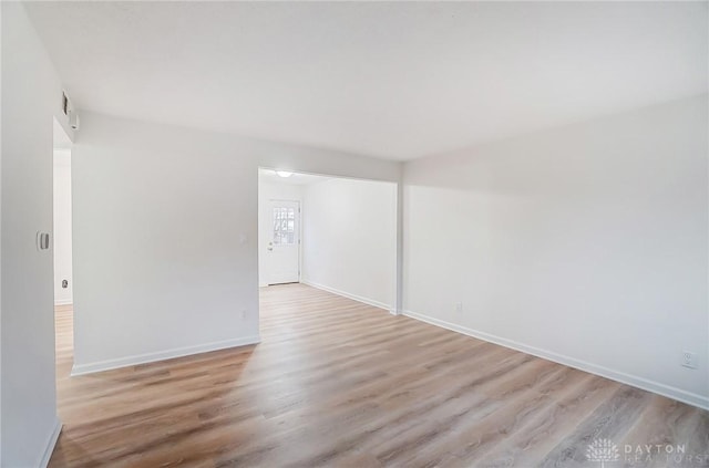 spare room featuring light wood finished floors and baseboards