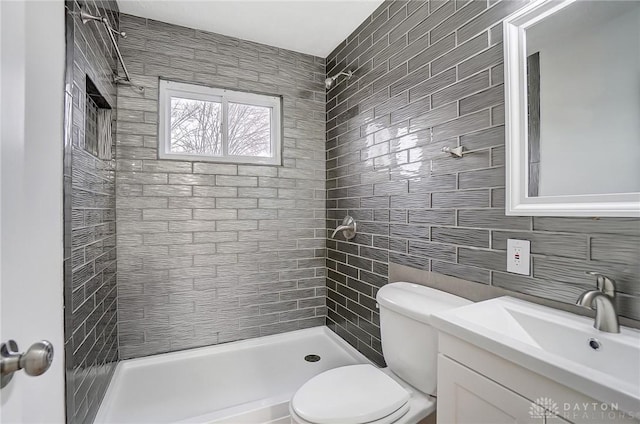 full bathroom with tasteful backsplash, tiled shower, vanity, and toilet