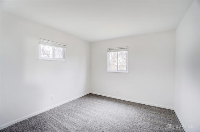 carpeted empty room with baseboards