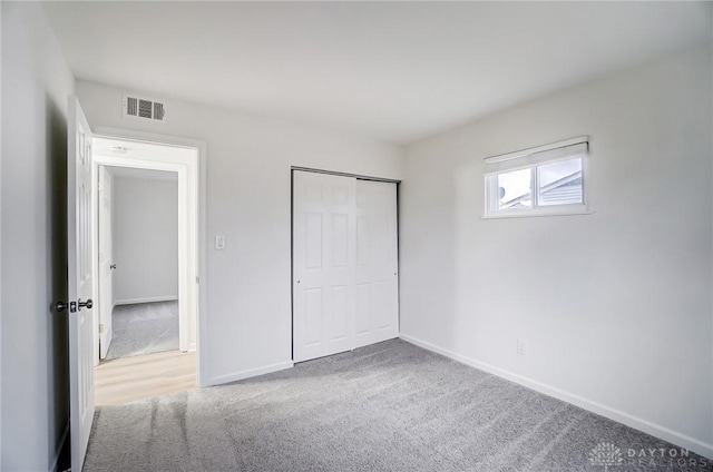 unfurnished bedroom featuring a closet, baseboards, visible vents, and carpet flooring