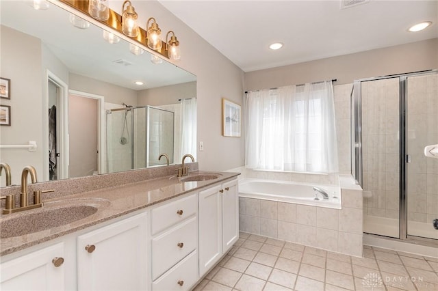 full bath featuring a garden tub, a sink, a shower stall, and tile patterned floors