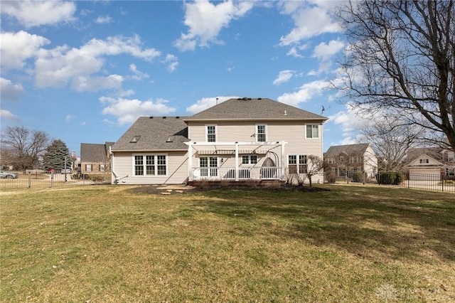 rear view of house featuring a fenced backyard and a lawn