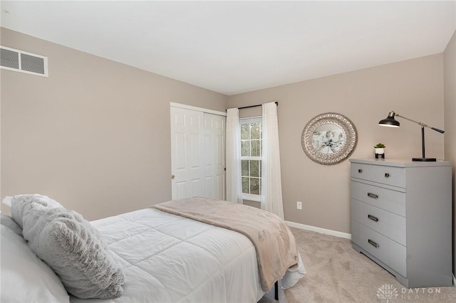 bedroom with light colored carpet, a closet, visible vents, and baseboards