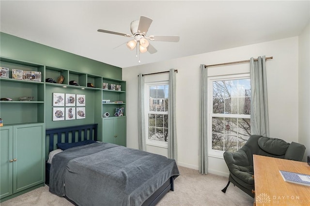 bedroom with light carpet, multiple windows, baseboards, and a ceiling fan