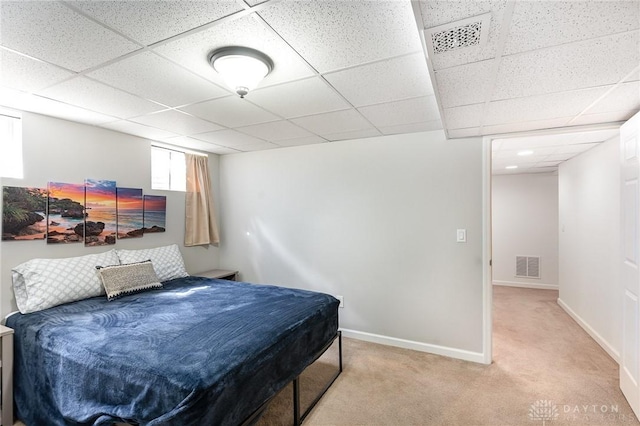 bedroom with baseboards, visible vents, a drop ceiling, and carpet flooring