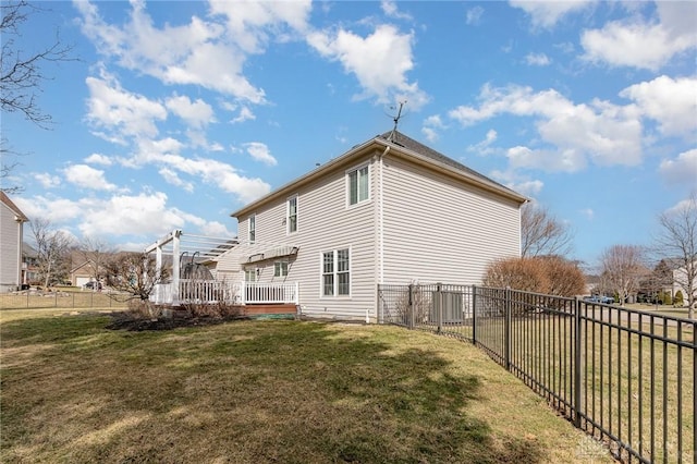 view of side of property featuring a fenced backyard, a deck, and a yard