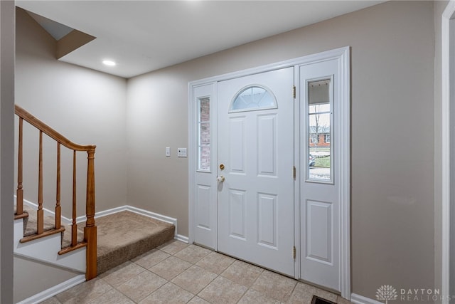 entrance foyer featuring recessed lighting, light tile patterned floors, baseboards, and stairs