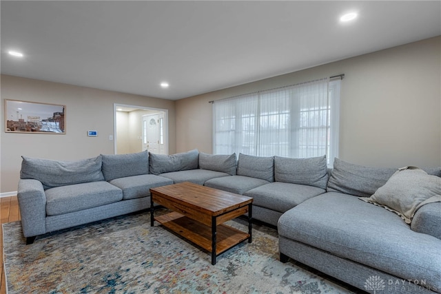 living room with baseboards, wood finished floors, and recessed lighting