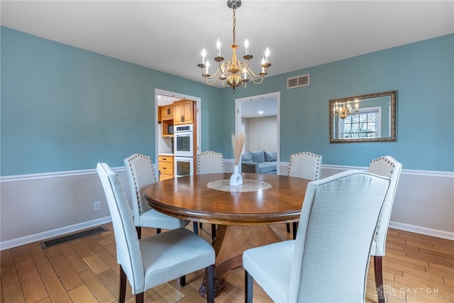 dining space with visible vents, light wood-style flooring, and baseboards