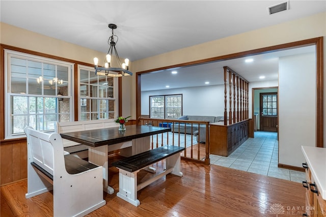 dining space featuring plenty of natural light, light wood-type flooring, visible vents, and a notable chandelier