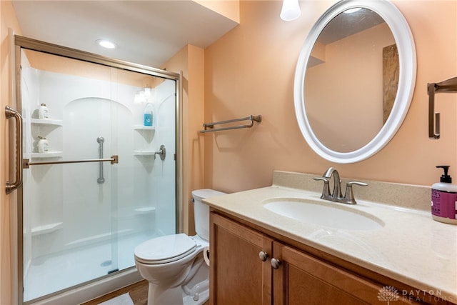 full bathroom with a stall shower, vanity, and toilet