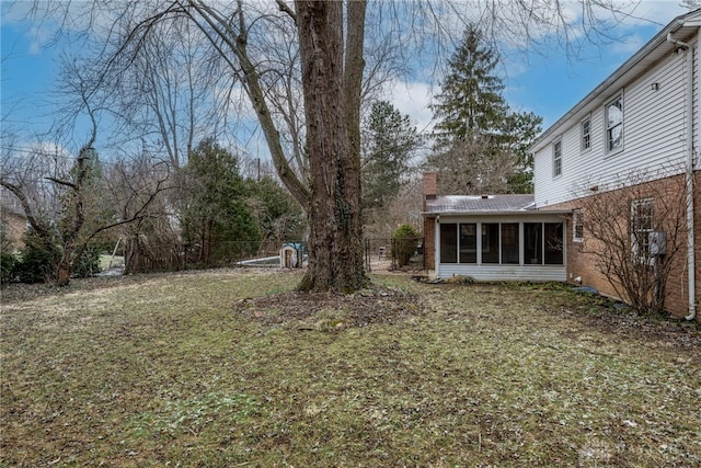 view of yard featuring fence and a sunroom