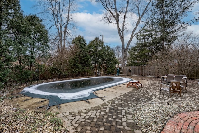 view of swimming pool featuring a fenced in pool, outdoor dining area, a patio, a fenced backyard, and a diving board