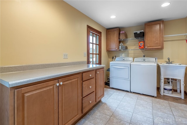 laundry area featuring light tile patterned floors, washing machine and dryer, cabinet space, and recessed lighting