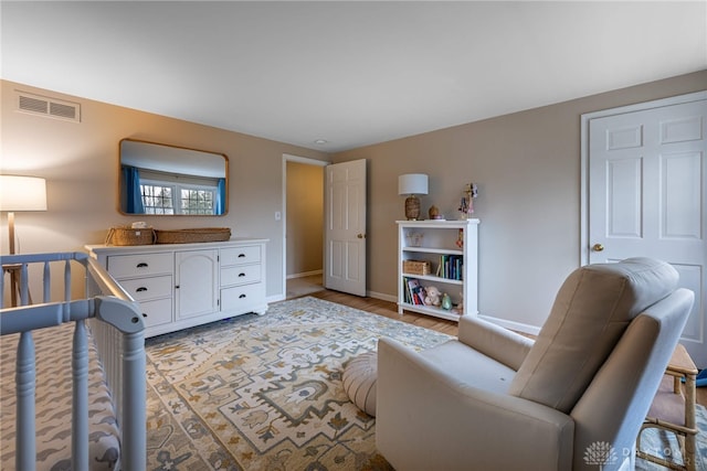 bedroom with light wood-style floors, baseboards, and visible vents