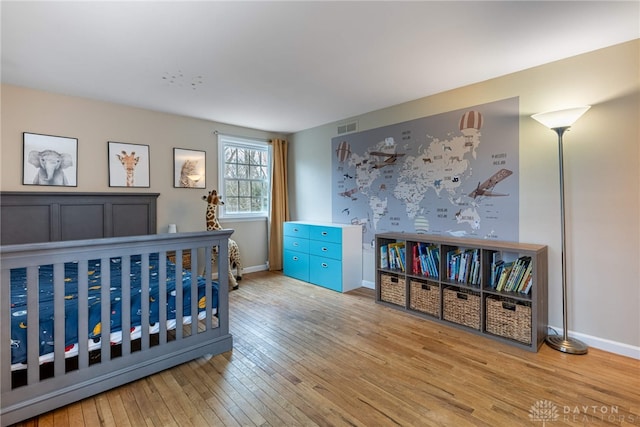 bedroom featuring light wood-type flooring, baseboards, and visible vents