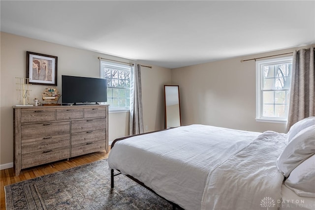 bedroom featuring wood finished floors and baseboards