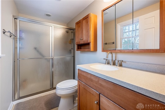 full bathroom with toilet, a shower stall, and vanity