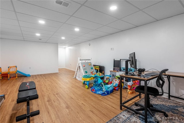 playroom featuring a paneled ceiling, wood finished floors, visible vents, and baseboards