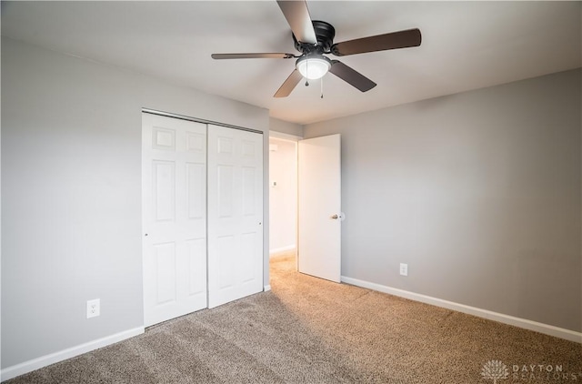 unfurnished bedroom featuring carpet, a closet, ceiling fan, and baseboards