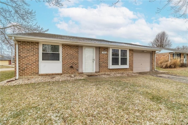 single story home with an attached garage, a front yard, and brick siding