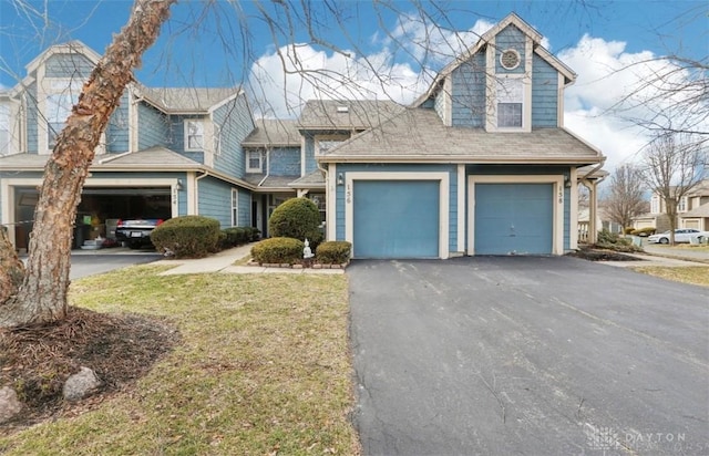 view of front of house with a garage, a front lawn, and aphalt driveway