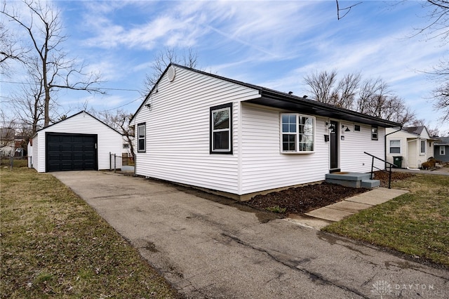 view of front facade with a front lawn, an outdoor structure, driveway, and a detached garage