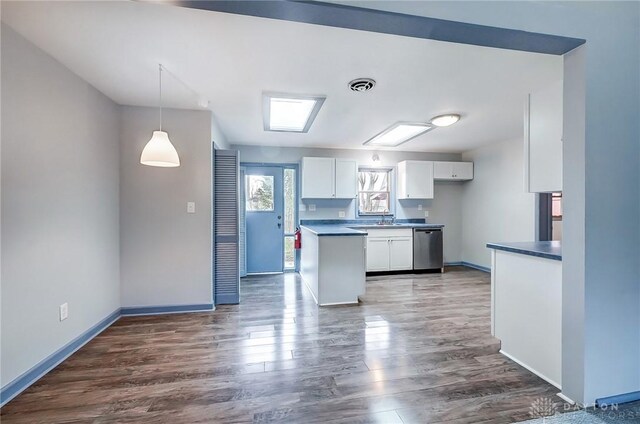 kitchen featuring wood finished floors, visible vents, white cabinets, dishwasher, and dark countertops